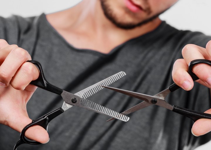 Cabeleireiro segurando tesoura de cabelo