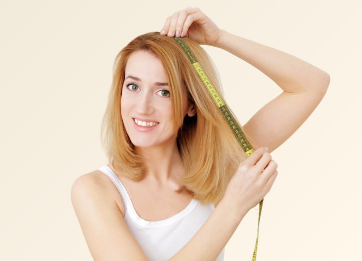 Mulher medindo o comprimento do pr&oacute;prio cabelo